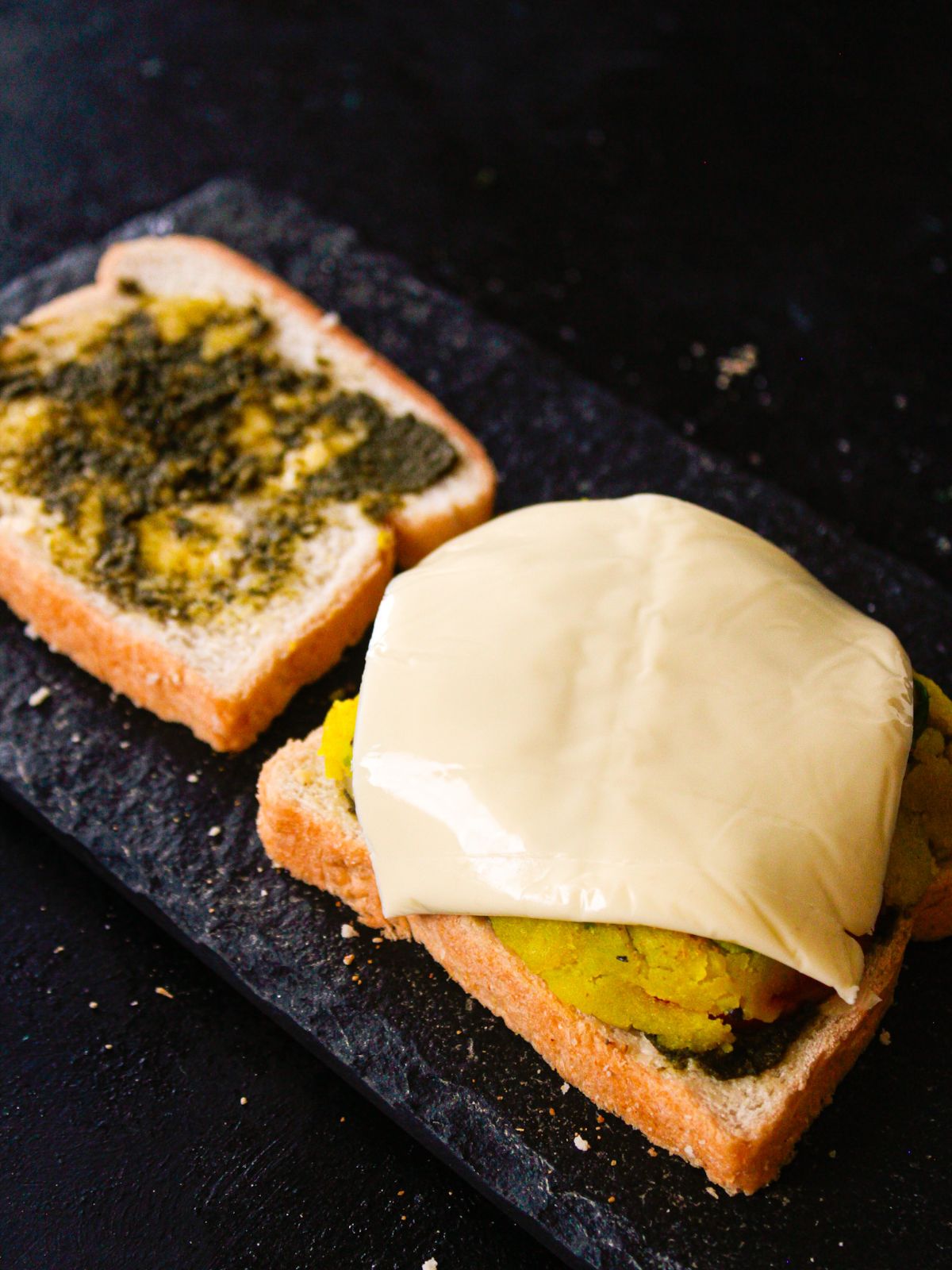 хлеб с зеленым чатни с одной стороны с начинкой, покрытой сыром напротив
