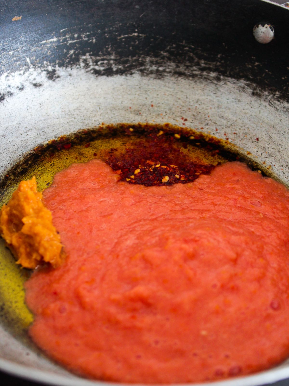 томатное пюре в сковороде с хлопьями красного перца