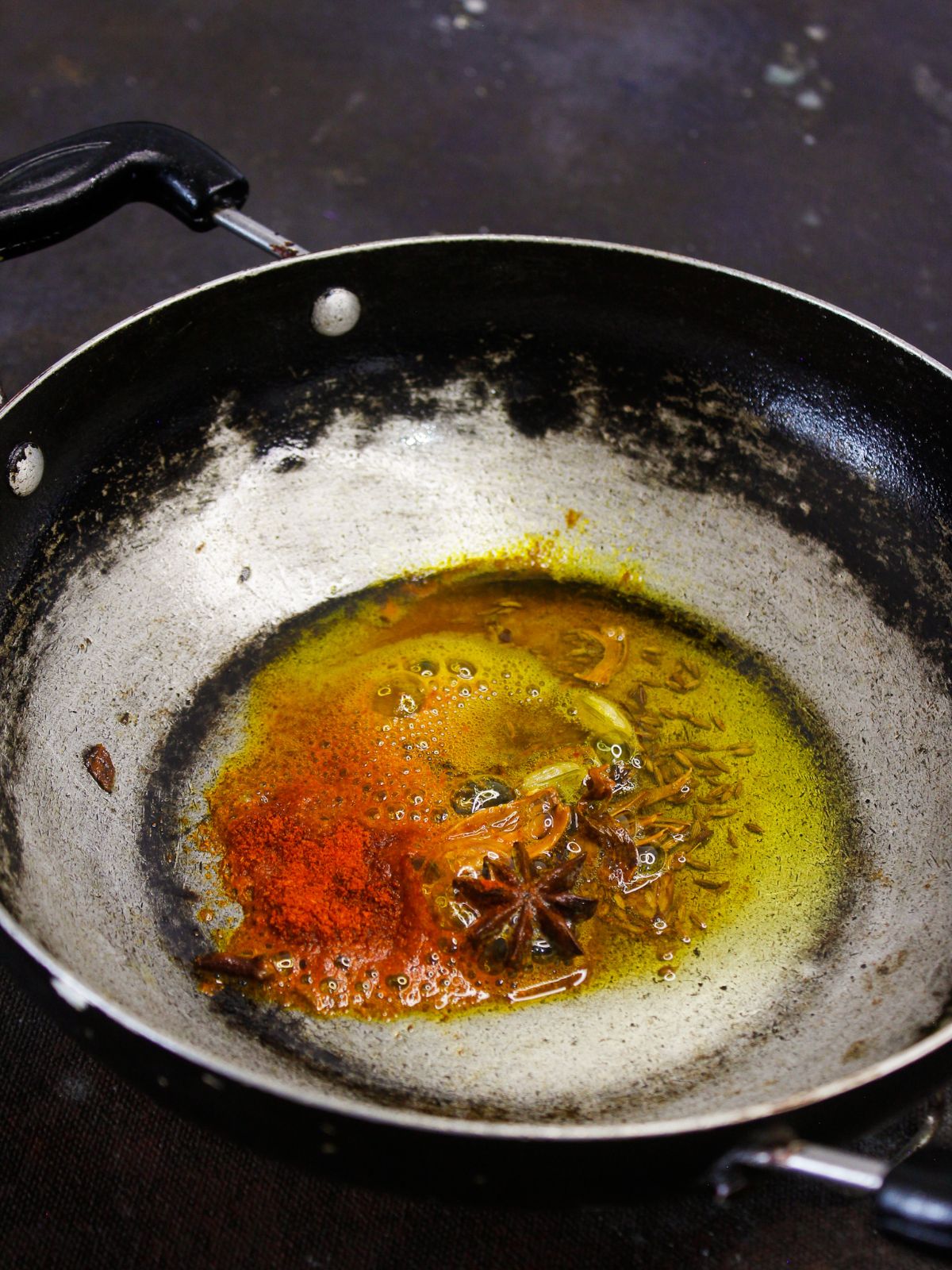 масло с травами и специями в масле в сковороде