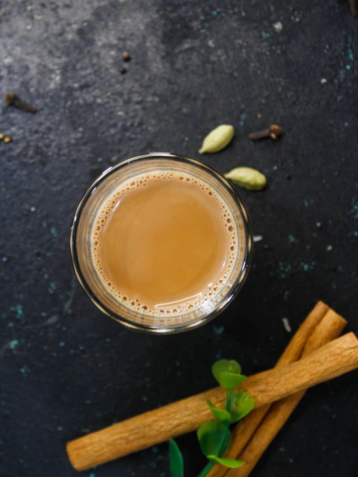 Масала-чай в стакане с травами