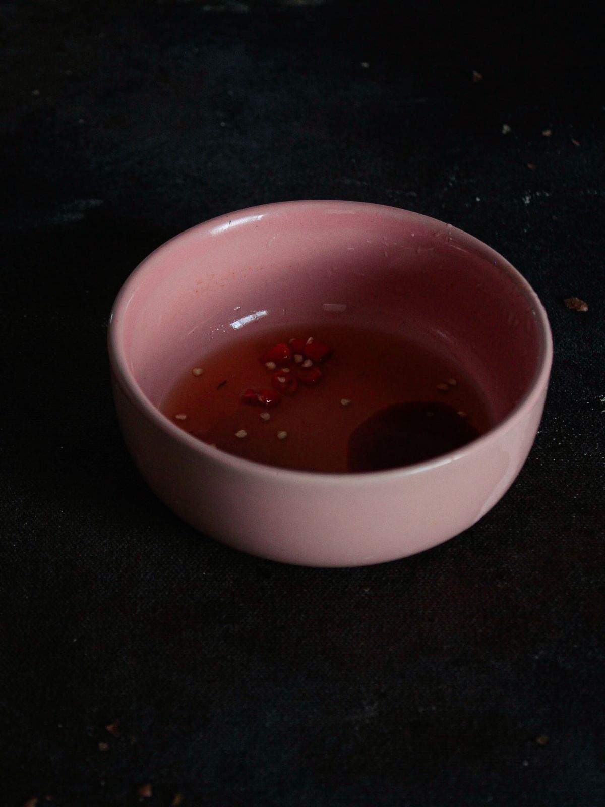 Соус для макания в розовой миске на черной поверхности